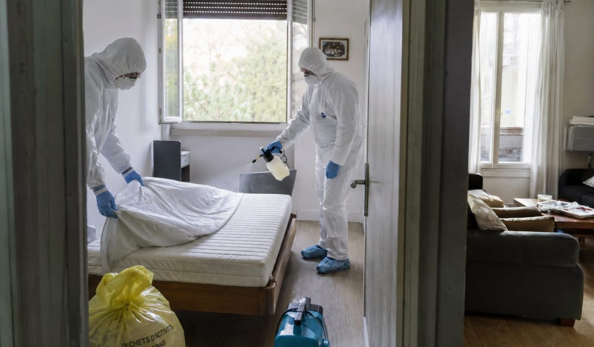 Techniciens spécialisés en combinaison de protection réalisant une désinfection professionnelle lors d’un nettoyage après décès dans un logement